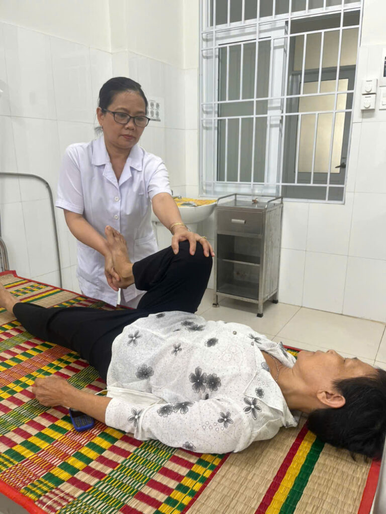 Ms. Kim Minh provides rehabilitation service for a patient.